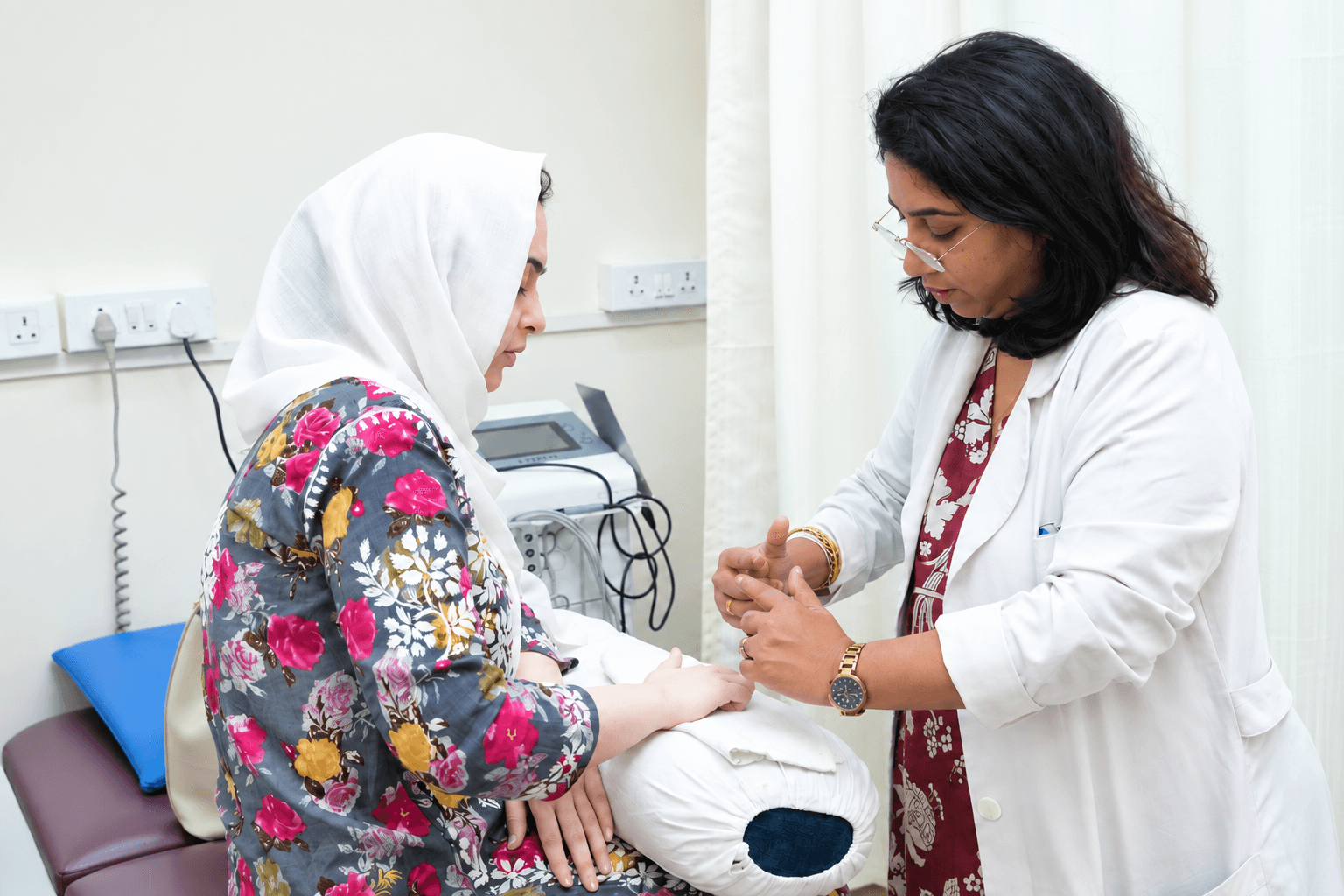 A physiotherapist assessing a patient's hand during a clinic session